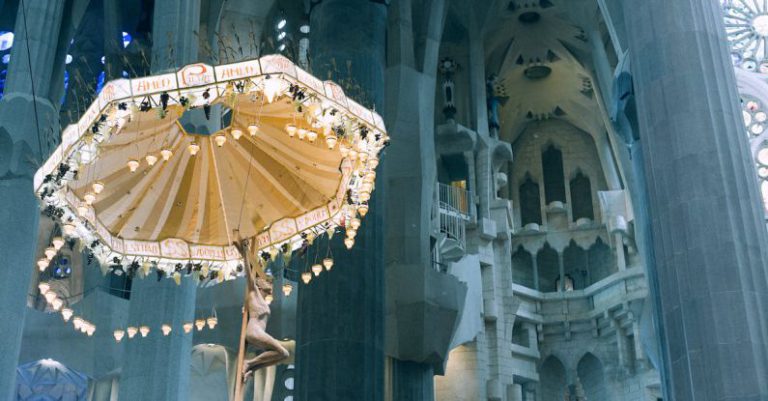 Born Cultural Barcelona - From below pillars and decorative ceiling with ornamental chandelier in Basilica de la Sagrada Familia in Barcelona