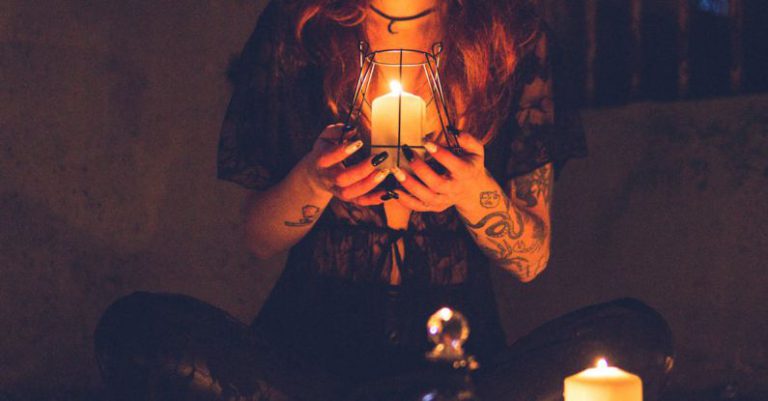 Gothic Night Barcelona - Spooky witch among candles during ritual