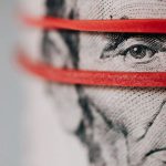 Currency Barcelona - Closeup of rolled United States five dollar bills tightened with red rubber band