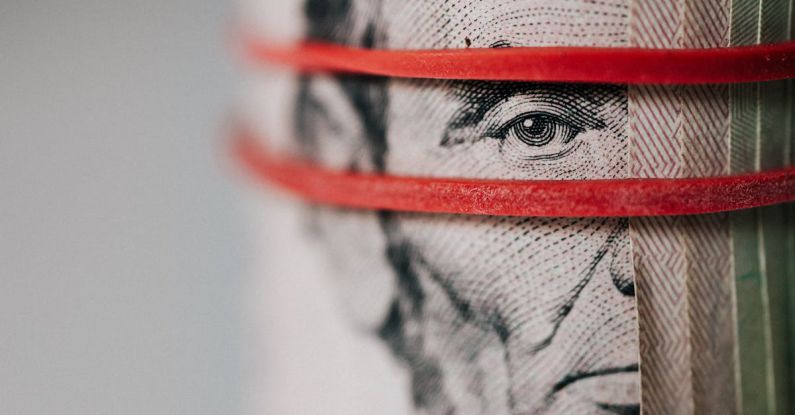 Currency Barcelona - Closeup of rolled United States five dollar bills tightened with red rubber band