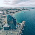 Barcelona - clear glass building near sea under grey sky