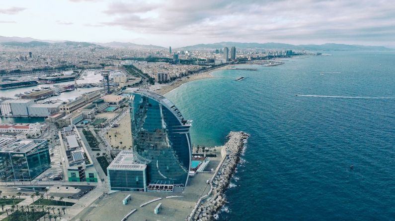 Barcelona - clear glass building near sea under grey sky