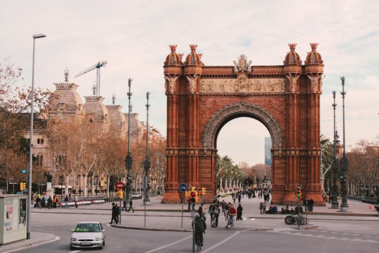 Barcelona - people walking on sidewalk near brown concrete building during daytime
