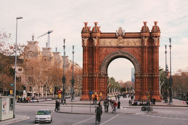 Barcelona - people walking on sidewalk near brown concrete building during daytime