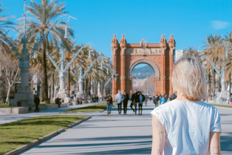 Barcelona - woman standing on road near concrete arch at daytime