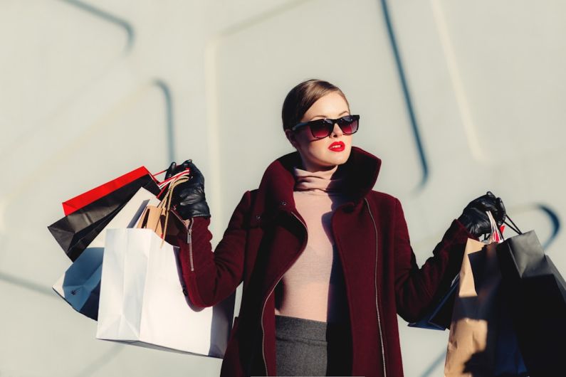 Shopping - photo of woman holding white and black paper bags